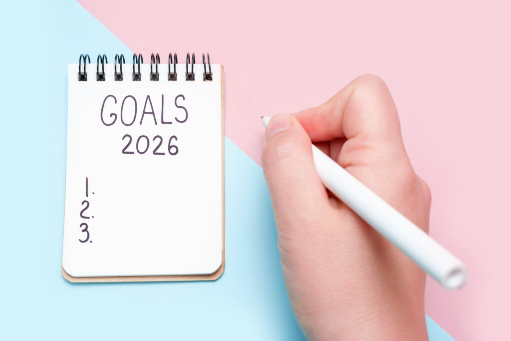 Hand writing in a notebook labeled “Goals 2026,” representing planning and focus on self-development goals.